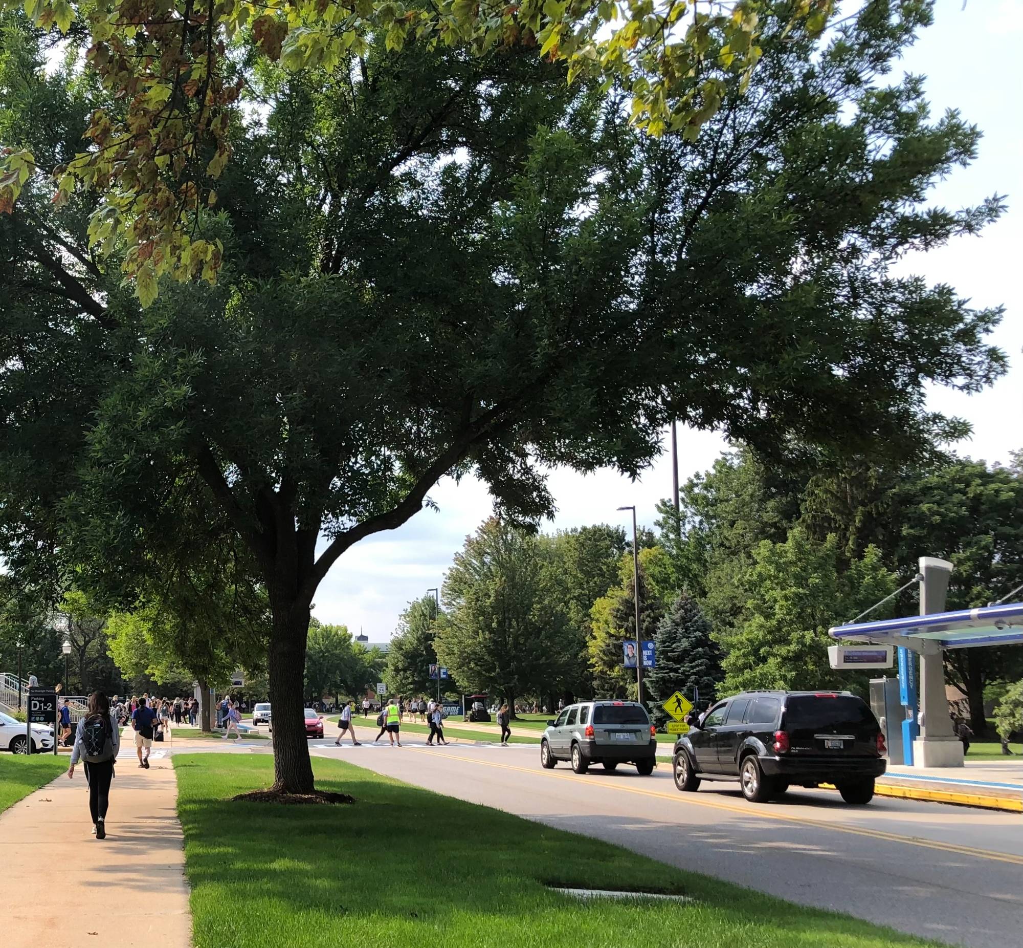 GVSU campus with students walking by Mackinac and bus stop